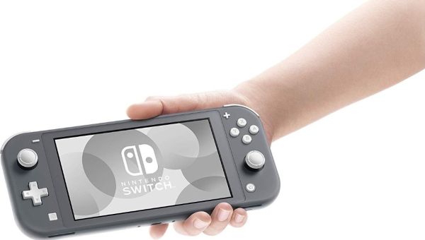 Hand holding a Nintendo Switch console with a clear screen showing the brand logo.